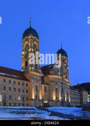 Einsiedeln, Switzerland - December 10, 2023: The Benedictine Abbey of Einsiedeln with its mighty basilica in blue hour in winter. Stock Photo