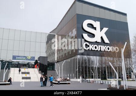 Moscow - April 10, 2024: Pan left of Skolkovo Innovation Center entrance showcasing people walking up the stairs and engaging in casual conversations, reflecting a dynamic business environment. Stock Photo
