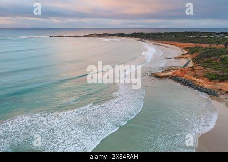Aerial view of gentle waves rolling into a gentle coastline at dawn at Point Roadknight on the Great Ocean Road in Victoria, Australia Stock Photo