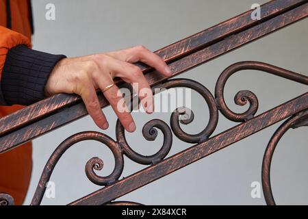 male hand holding the railing on the stairs, go up the stairs Stock Photo
