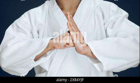 Man, hands and karate form in studio, fighter and ready for training or practice on dark background. Male person, athlete and warrior in dojo for Stock Photo