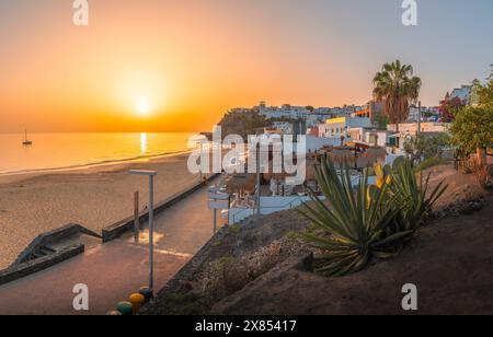 Bask in the warm glow of sunset at Morro Jable, Fuerteventura, where golden sands meet tranquil Atlantic waters Stock Photo