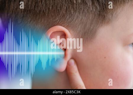 ear closeup, child listening, sound wave, acoustics and sound vibrations, Auditory System, Hearing Test, Cochlear implant, Assistive listening device Stock Photo