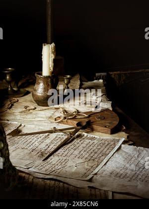 Navigational equipment old map and papers with a candle on a desk of a historical wooden vintage ship on the captain's desk. Adventure and travel conc Stock Photo