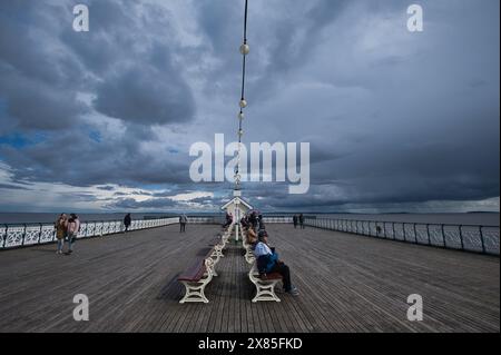 Storm clouds gather over  Penarth Pier in early Spring Stock Photo
