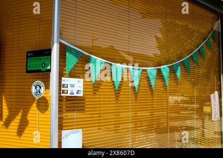 Green pendants against orange blinds in shop window Stock Photo