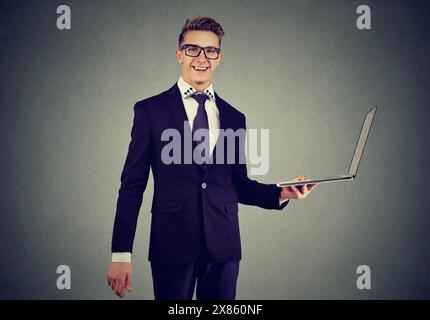 Happy young business man making a choice in favor of a new light laptop Stock Photo