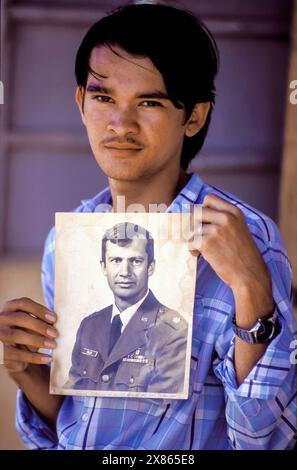 Philippines, Luzon; Refugee boy from Vietnamese mother and american father showing a picture of his father. Stock Photo