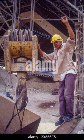 Philippines, Davao; Construction worker at a pulley in a cement factory. Stock Photo