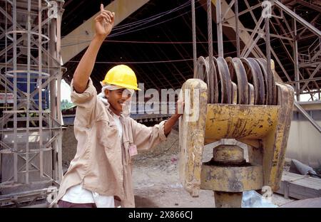 Philippines, Davao; Construction worker at a pulley in a cement factory. Stock Photo