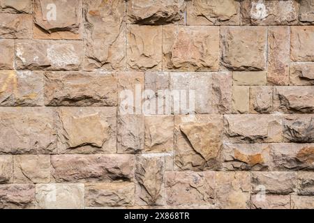 Solid house stone wall of roughly hewn stone closeup as stone background Stock Photo