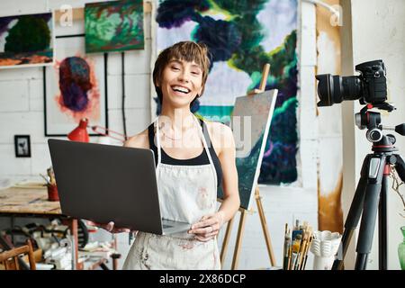 A woman confidently stands in front of a laptop computer. Stock Photo