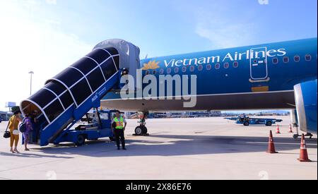 Passengers board, via passenger boarding stairs, a Vietnam Airlines Airbus A321 at Cam Ranh International Airport, IATA: CXR, near  Nha Trang, Vietnam Stock Photo