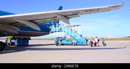 Passengers board, via passenger boarding stairs, a Vietnam Airlines Airbus A321 at Cam Ranh International Airport, IATA: CXR, near  Nha Trang, Vietnam Stock Photo