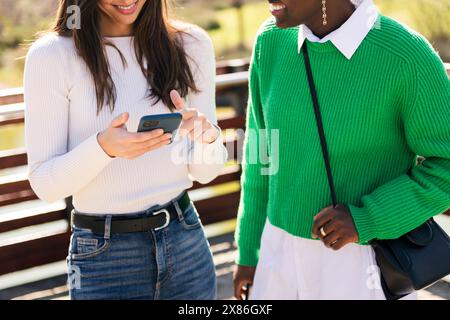 two unrecognizable young women using mobile phone Stock Photo