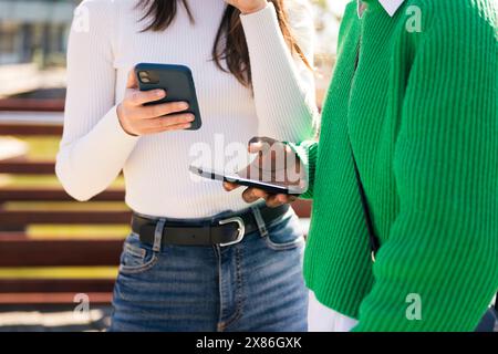 two unrecognizable young women using mobile phones Stock Photo