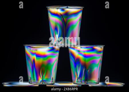 Three stacked transparent clear plastic drinks shot glasses viewed between crossed polarising filters. Stock Photo