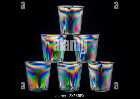 Six stacked transparent clear plastic drinks shot glasses viewed between crossed polarising filters. Stock Photo