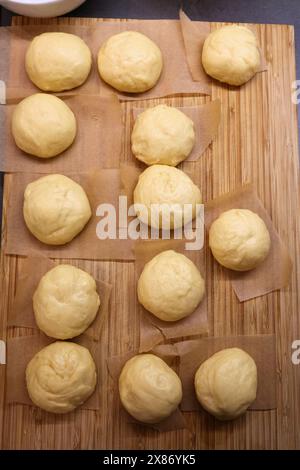 Making homemade yeast raised donuts - raw dough balls before frying. Polish donuts made for Tlusty Czwartek (Fat Thursday) holiday in Poland. Stock Photo