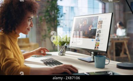 Middle Eastern Female Working in Creative Agency, Implementing Modern Business Strategy for Clients. Successful Specialist Using Computer, Watching Video about Cameras. Stock Photo