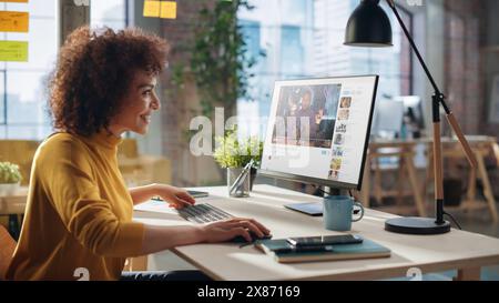 Middle Eastern Female Working in Creative Agency, Implementing Modern Business Strategy for Clients. Successful Specialist Using Computer, Watching Video about Cameras. Stock Photo