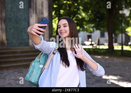 Beautiful travel blogger with smartphone streaming outdoors Stock Photo