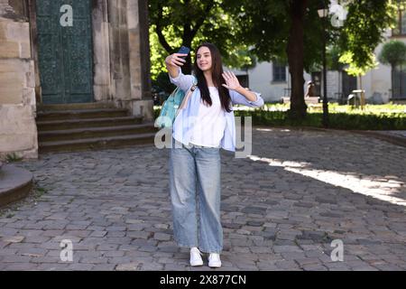 Beautiful travel blogger with smartphone streaming outdoors Stock Photo