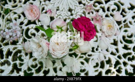 Garden roses on a white metal table. Picture taken from above. Stock Photo