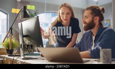 Art Director and Graphic Designer Discussing a Marketing Campaign for Business Partner. Successful Female and Male Colleagues Collaborating on a Project. Small Creative Team Working in the Office. Stock Photo