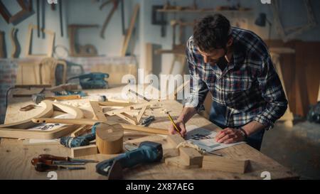 Young Woodworker Checking the Layout Manual of a Stylish Handmade Wooden Chair. Talented Furniture Designer Working in a Workshop in a Creative Loft Space with Tools and Equipment. Stock Photo