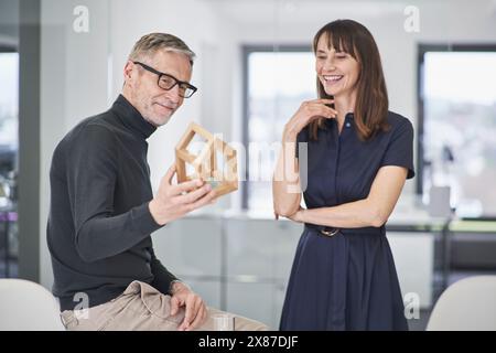 Two smiling architects looking at model house in office Stock Photo