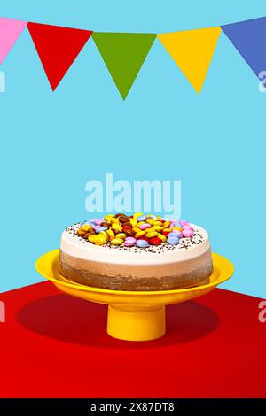 Chocolate and vanilla birthday cake with colorful toppings and decoration against blue background Stock Photo