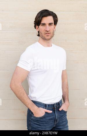 Confident young handsome man standing hands in pockets Stock Photo