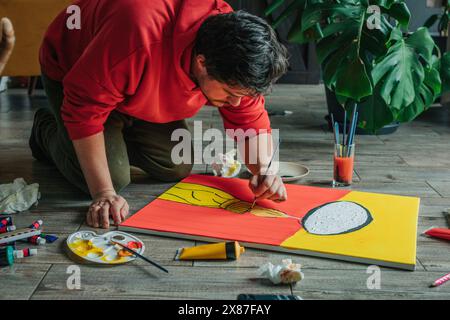Painter painting on canvas over floor at home Stock Photo