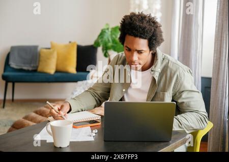 Businessman with Afro hairstyle using laptop working at home office Stock Photo