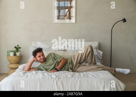 Young man relaxing on bed in bedroom at home Stock Photo
