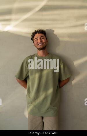 Happy young man leaning on wall Stock Photo