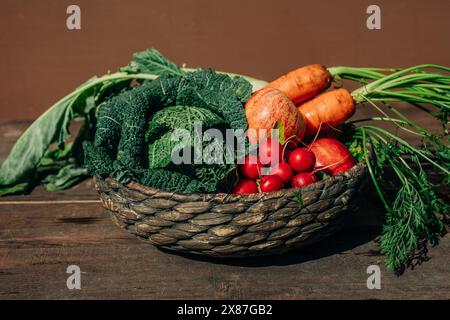 Fresh organic vegetables and fruits in wicker basket on table Stock Photo