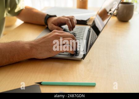 Hands of freelancer typing on laptop at home Stock Photo