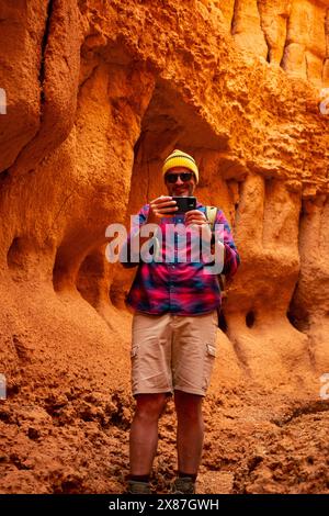 Smiling mature man photographing in red canyon Stock Photo