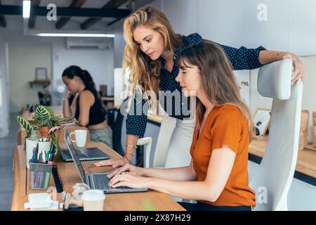 Business colleagues discussing over laptop planning strategy in office Stock Photo