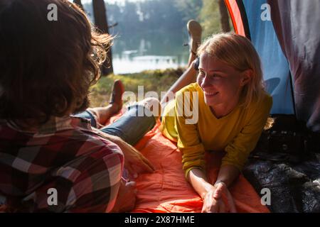 Smiling woman spending leisure time with boyfriend in tent Stock Photo