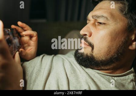 Man playing games on smartphone at home Stock Photo