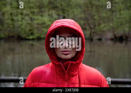 Woman wearing red jacket in rain at forest Stock Photo