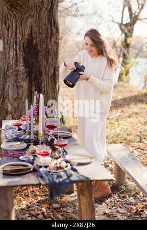 Beautiful woman clicking photos through camera in forest Stock Photo