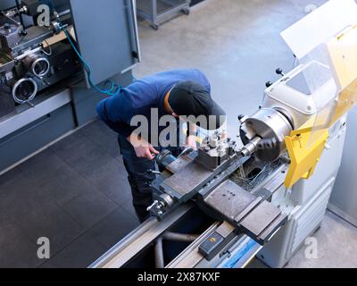 Metalworking worker operating lathe machine in metal industry Stock Photo