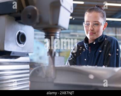 Factory worker operating CNC machine in industry Stock Photo