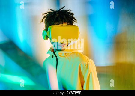 Man in yellow jacket wearing virtual reality headset Stock Photo