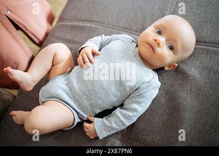 Baby boy lying on sofa at home Stock Photo
