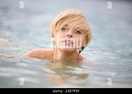 Beautiful young blond woman swimming in lake Stock Photo